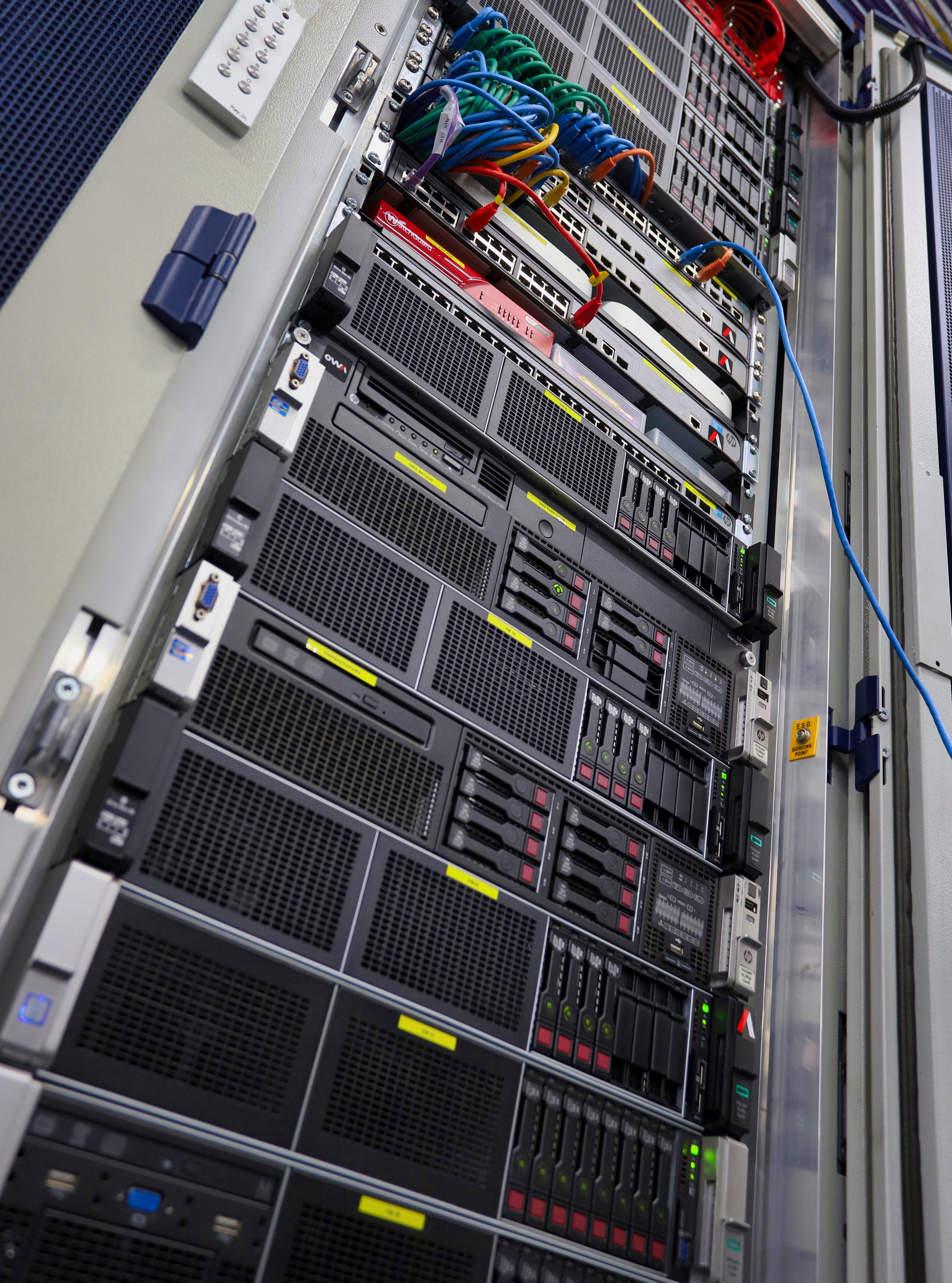 A rack of servers lined up in a data center, showcasing multiple units with blinking lights and cables.